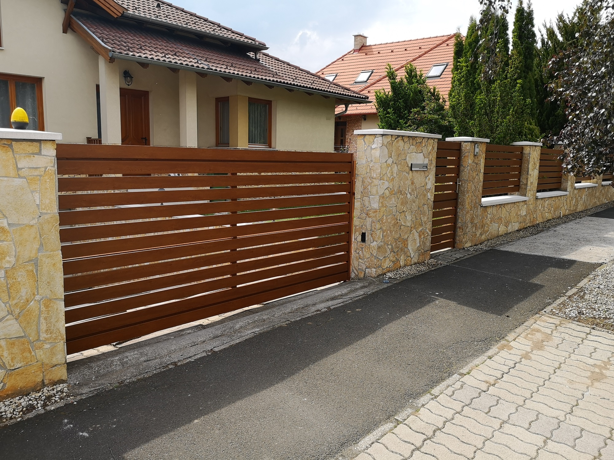 Recinzione metallica con pannelli orizzontali e pilastri in muratura