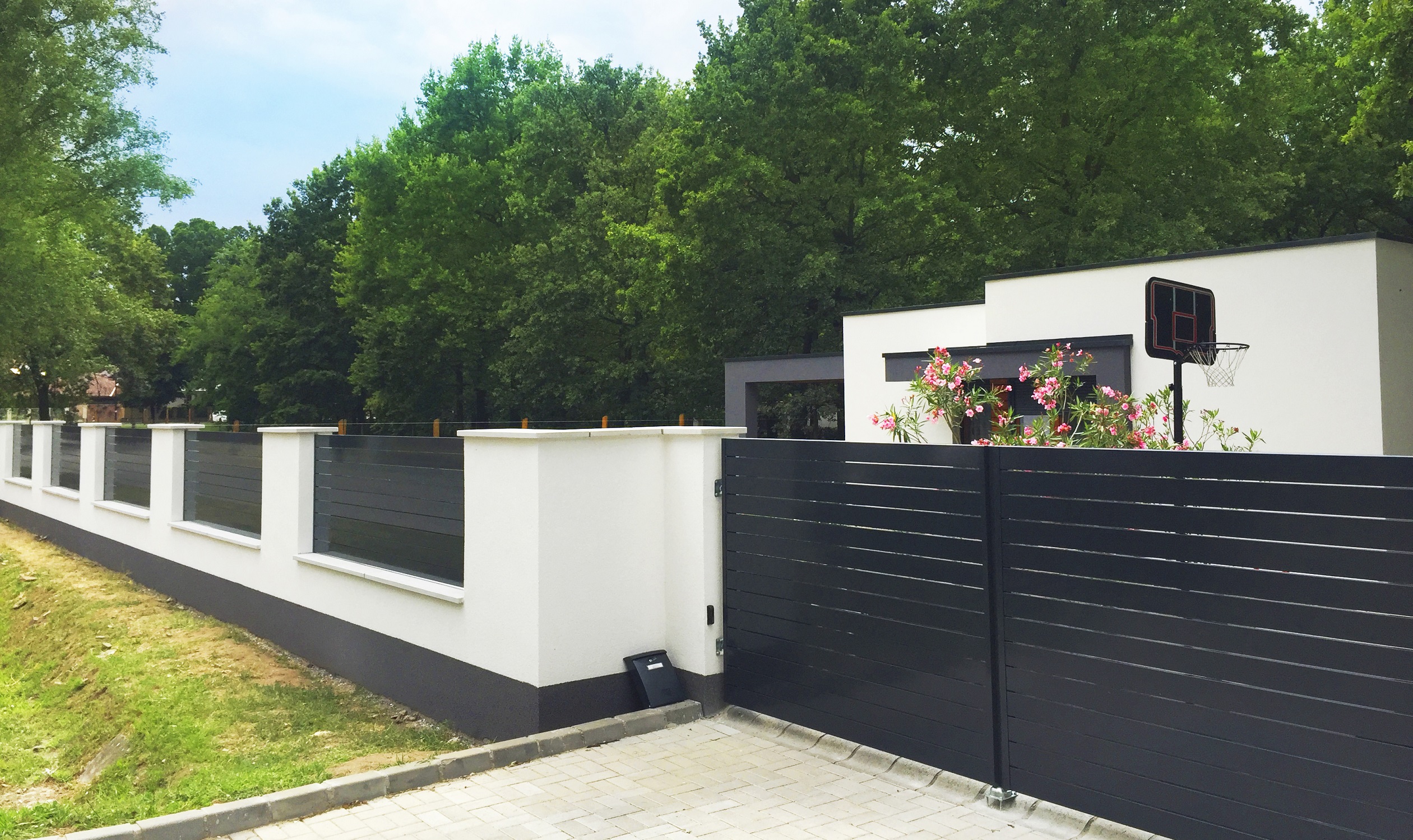 Cancello scorrevole e recinzione antracite su muro moderno